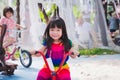 Cute Asian girl riding a tricycle. Happy child wear colorful dresses. Kid smile sweetly. Children exercise on the playground. Royalty Free Stock Photo
