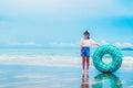 Cute asian girl on summer sea beach holding swim ring, wearing hat, eyeglasses and smiling with happiness, people on summer Royalty Free Stock Photo