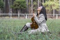 Cute asian girl with a violin on the grass on blurred woods background Royalty Free Stock Photo