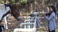 Cute asian girl with a violin and horses on blurred woods background Royalty Free Stock Photo