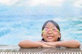 Cute asian girl wear goggle and smile in swimming pool