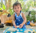 Cute Asian girl wearing apron having fun preparing or making cookie cutter sandwiches at home Royalty Free Stock Photo