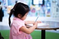 Cute Asian girl is writing book intently with pencil, child practicing calligraphy, children doing homework assigned by teacher Royalty Free Stock Photo