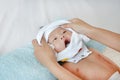 Cute asian infant baby boy lying on bed and mother while put on some clothes to her baby after bath Royalty Free Stock Photo