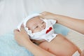 Cute asian infant baby boy lying on bed and mother while put on some clothes to her baby after bath Royalty Free Stock Photo