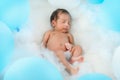 Asian infant baby boy sleeping on bed among blue and white balloon Royalty Free Stock Photo