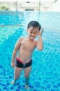 Cute asian kid cleaning ears after swimming in a pool Royalty Free Stock Photo