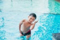 Cute asian kid cleaning ears after swimming in a pool Royalty Free Stock Photo