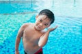 Cute asian kid cleaning ears after swimming in a pool Royalty Free Stock Photo