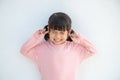 Cute Asian kid girl covered ears the fingers and gesturing that not want to listen on white background with empty copy space