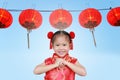 Cute asian kid girl in Traditional Chinese dress against aligned Chinese Red Lanterns, Chinese new year concept Royalty Free Stock Photo