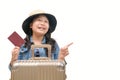 Cute asian kid ready to travel wearing a hat and holding her passport with luggage Royalty Free Stock Photo