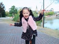 Cute Asian little beautiful girl play at autumn in the city park Royalty Free Stock Photo