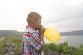 Cute asian little boy blowing balloon