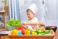 Cute Asian little boy child wearing chef hat and apron having fun preparing, cooking healthy food in kitchen, Fun indoor