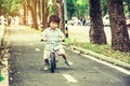 Cute asian little boy, spinning training cycling on lens for the bike in the park of public park, concept cute child,fun and