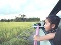 Cute asian little child girl blowing bubble out of car window Royalty Free Stock Photo