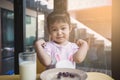 Asian little child girl drinking milk and eating snack and make strong gesture in breakfast time Royalty Free Stock Photo