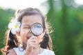 Cute asian little child girl looking through a magnifying glass Royalty Free Stock Photo