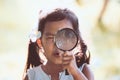 Cute asian little child girl looking through a magnifying glass Royalty Free Stock Photo