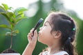 Cute asian little child girl looking through a magnifying glass Royalty Free Stock Photo