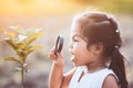 Cute asian little child girl looking through a magnifying glass Royalty Free Stock Photo