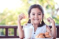 Cute asian little child girl making strong hand while drinking