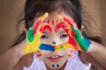 Cute asian little child girl with painted hands make heart shape