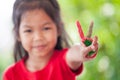 Asian little child girl with painted hands showing fingers number two