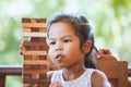 Cute asian little child girl pay attention to play wood blocks