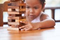 Cute asian little child girl pay attention to play wood blocks