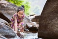 Cute asian little child girl playing paper boat in the riverside