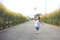 Cute asian little child girl playing with wind turbine and run Royalty Free Stock Photo