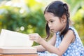 Cute asian little child girl reading a book in outside Royalty Free Stock Photo