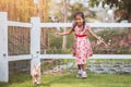 Cute asian little child girl running to catch a rabbit with fun