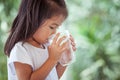 Cute asian little girl drinking fresh water from glass Royalty Free Stock Photo