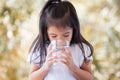 Cute asian little girl drinking fresh water from glass Royalty Free Stock Photo