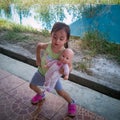 Cute Asian little girl embracing her doll. outdoor, natural light Royalty Free Stock Photo