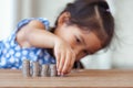 Cute asian little girl playing with coins making stacks of money Royalty Free Stock Photo