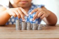 Cute asian little girl playing with coins making stacks of money Royalty Free Stock Photo