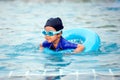 Cute asian little girl with swim ring is having fun to swim