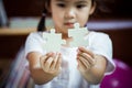 Cute asian little girl is trying to connect couple jigsaw puzzle Royalty Free Stock Photo