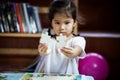 Cute asian little girl is trying to connect couple jigsaw puzzle Royalty Free Stock Photo