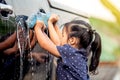 Cute asian little girl washing car Royalty Free Stock Photo