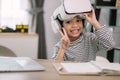 Cute Asian little girl wearing VR glasses with a laptop placed on the table in STEM technology class. Online education. Erudition