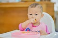 Cute Asian baby girl child eating by hands, Little baby eating vegetables with BLW method, baby led weaning, Self Feeding concept Royalty Free Stock Photo