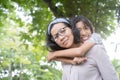 Cute Asian mother and daughter playing and  giving ride on back together at  park, Happy family concept Royalty Free Stock Photo