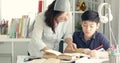 Cute asian mother helping your son doing your homework . Royalty Free Stock Photo