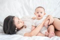 Cute Asian newborn baby boy sitting play on white bed with smile happy face. Royalty Free Stock Photo