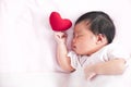 Cute asian newborn baby girl sleeping with red heart Royalty Free Stock Photo